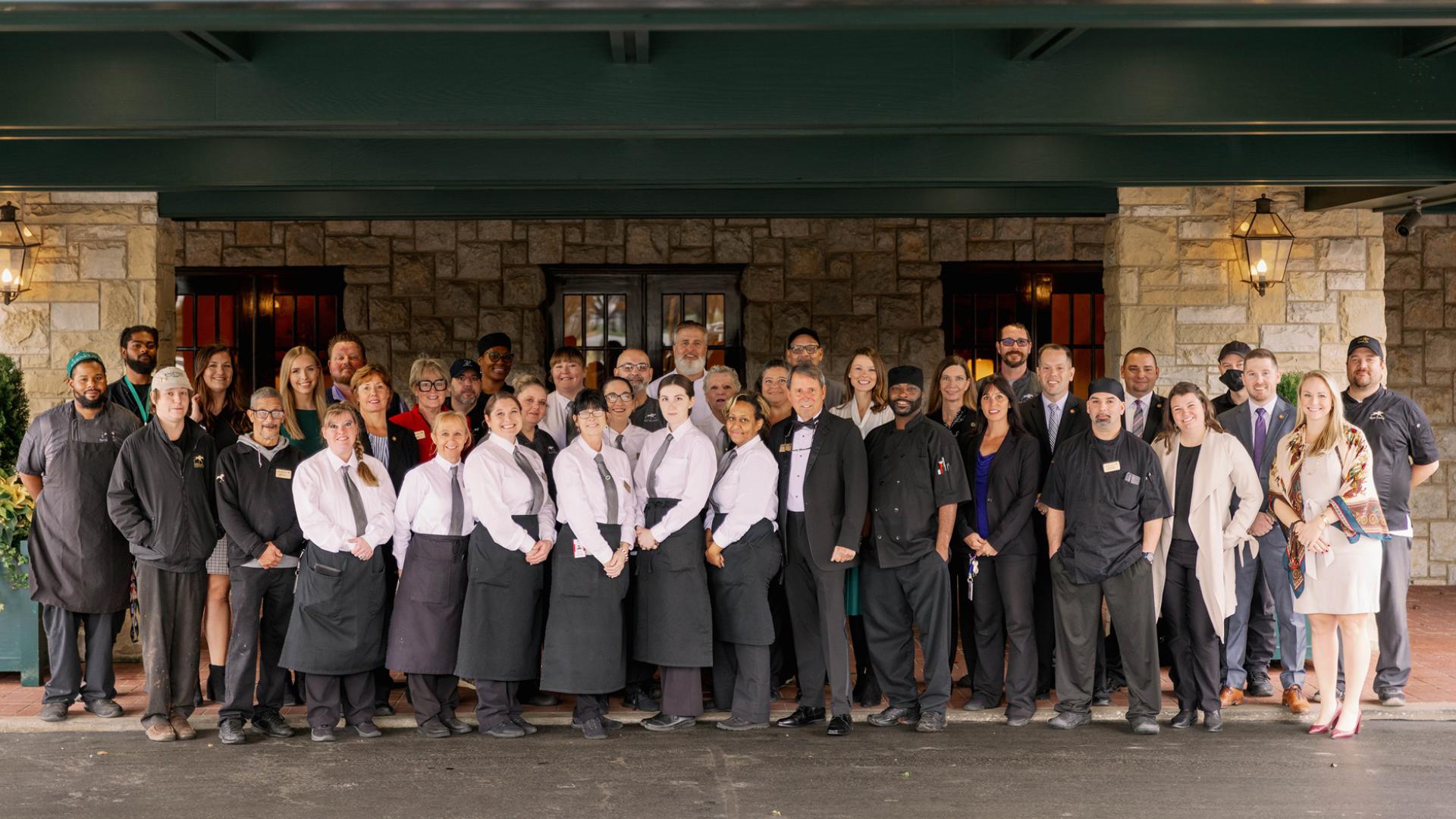 Keeneland team standing at the front of the clubhouse. Team wearing black and white clothes.
